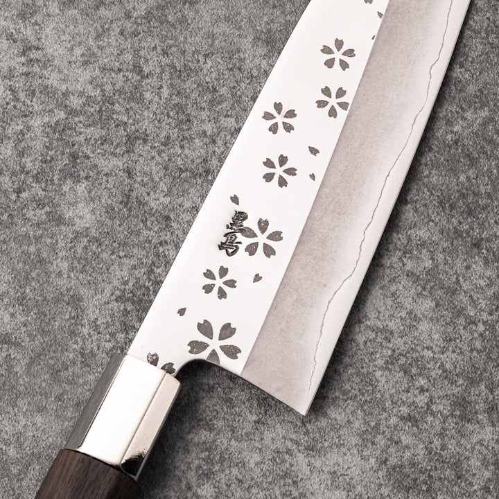 Elegant Japanese kitchen knife with cherry blossom cutout pattern on the blade, featuring a sharp edge and dark wooden handle for precise cutting.