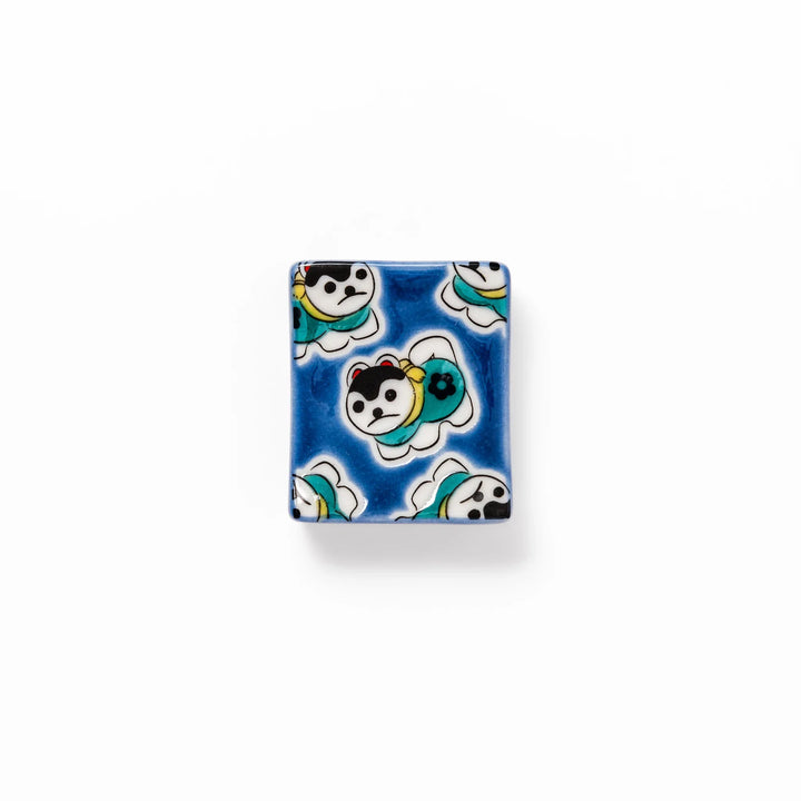 Rectangular Japanese ceramic chopstick rest with a deep blue background decorated with playful lucky dog motifs, bringing charm and fun to dining tables.