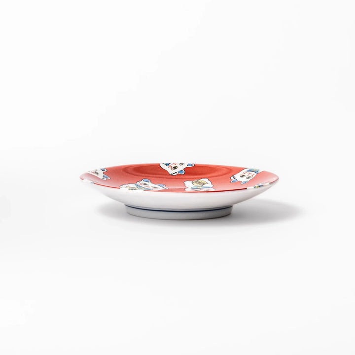 Round Japanese ceramic sauce dish with a red background decorated with playful maneki neko lucky cats, perfect for serving soy sauce or small condiments.