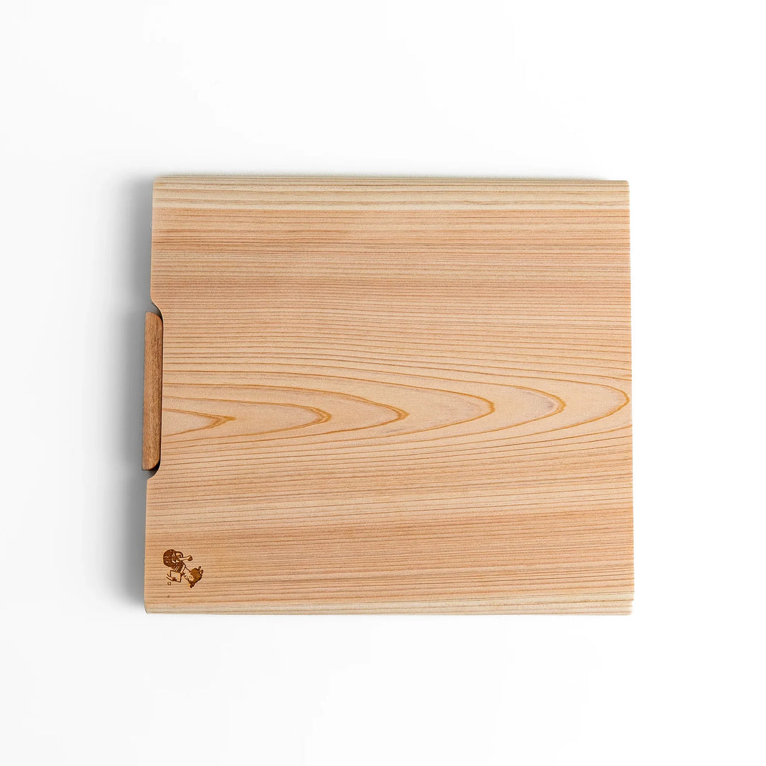 Medium Hinoki wood cutting board with natural grain, side handle, engraved motif, and smooth finish, crafted in Japan