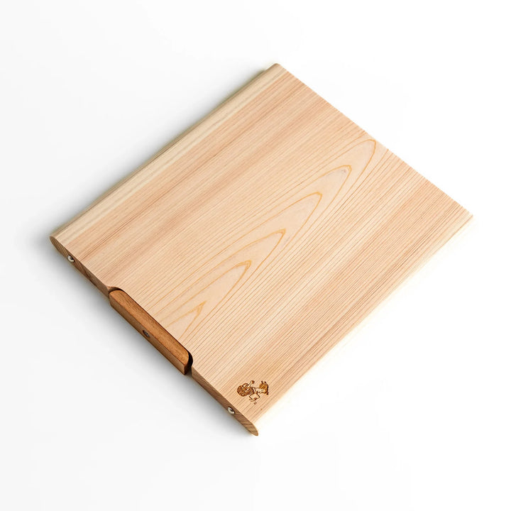 Medium Hinoki wood cutting board with natural grain, side handle, engraved motif, and smooth finish, crafted in Japan