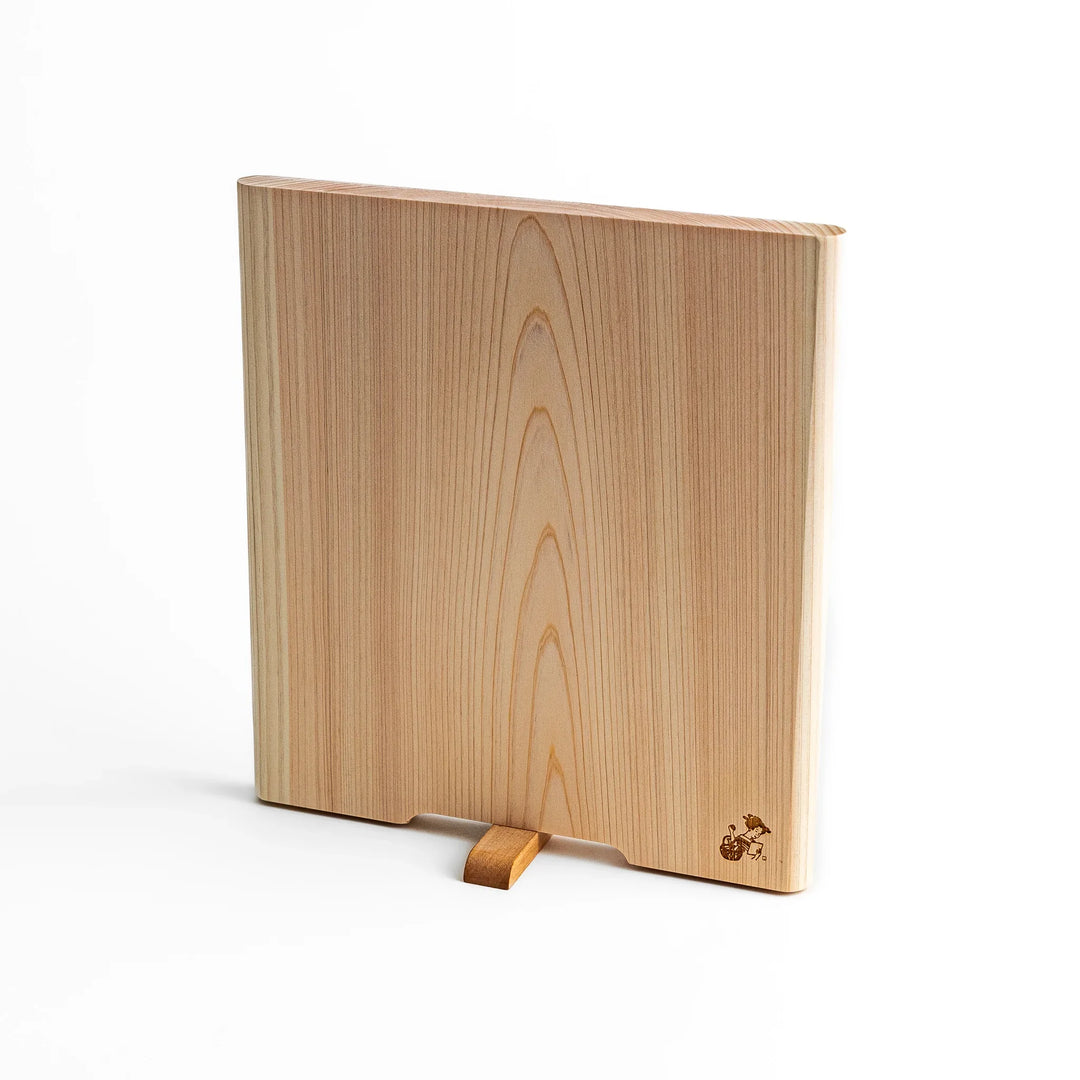 Medium Hinoki wood cutting board with natural grain, side handle, engraved motif, and smooth finish, crafted in Japan
