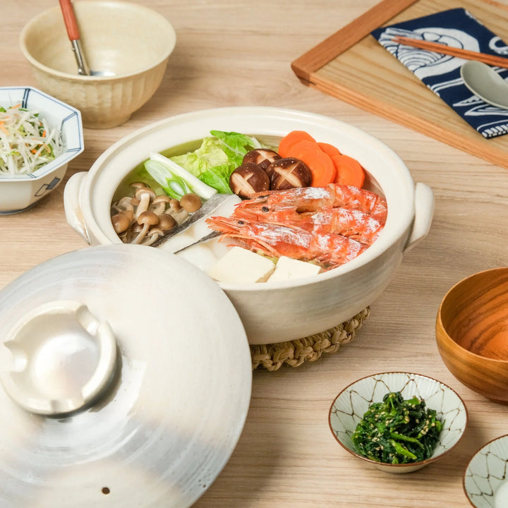 Japanese donabe clay pot filled with shrimp, tofu, mushrooms, and vegetables, ideal for hot pot cooking and cozy family meals.