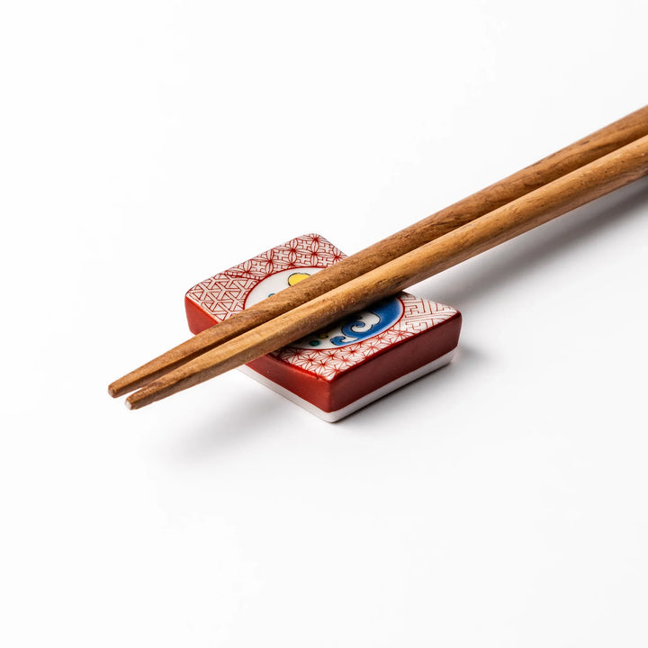 Rectangular Japanese ceramic chopstick rest with red geometric pattern and moon rabbit motif, blending playful design and tradition for a charming table accent.