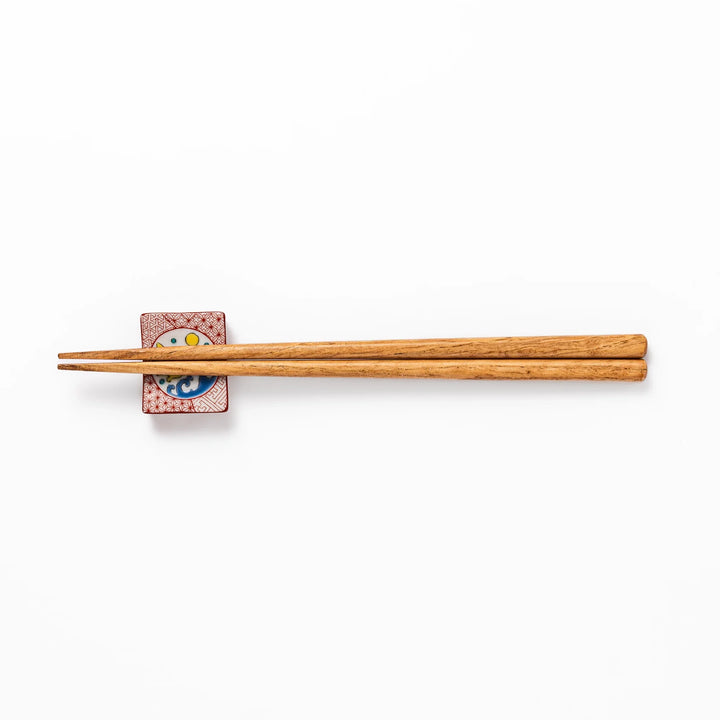 Rectangular Japanese ceramic chopstick rest with red geometric pattern and moon rabbit motif, blending playful design and tradition for a charming table accent.