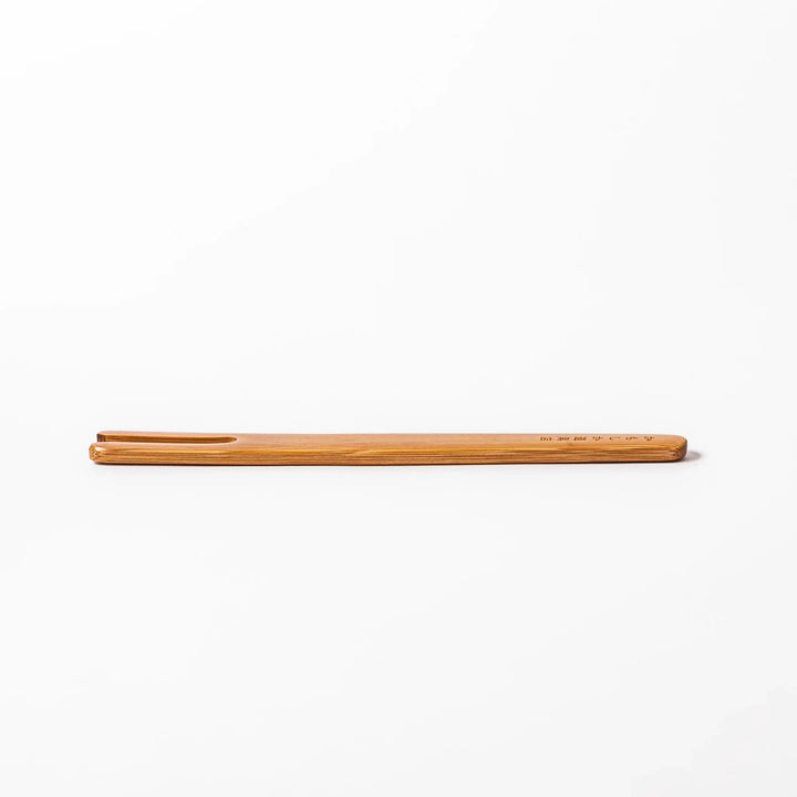 Bamboo natto stirring stick with a split-tip design and engraved Japanese text, ideal for mixing natto evenly and gently.