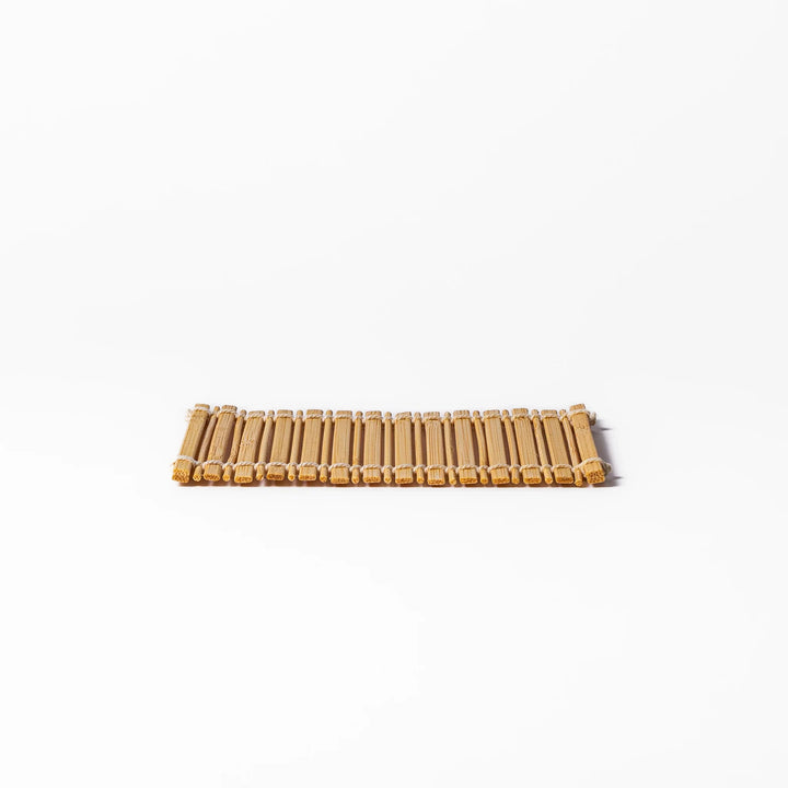 Natural finish bamboo coaster with uniform vertical slats and white cord ties, bringing a warm, organic accent to your Japanese-style table setting.