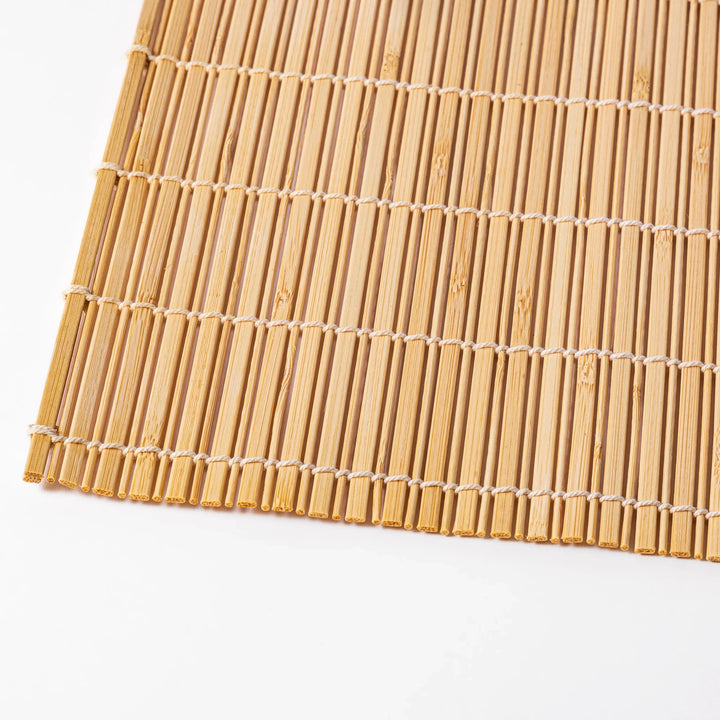 Natural finish bamboo table mat with slim vertical slats and white cord binding, offering a clean, earthy touch to traditional Japanese table settings.