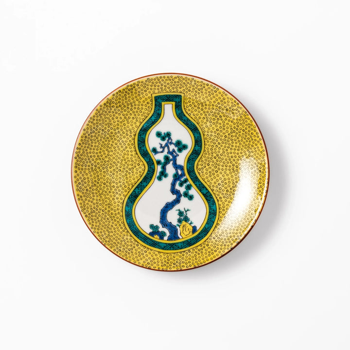 Japanese dessert plate featuring a yellow patterned background with a gourd-shaped center, showcasing a blue pine tree and green foliage.