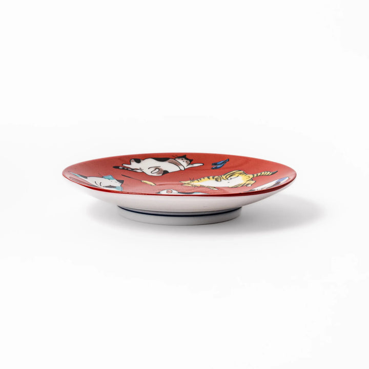 Red Japanese porcelain sauce dish featuring playful cat illustrations in various poses, perfect for soy sauce or dipping.