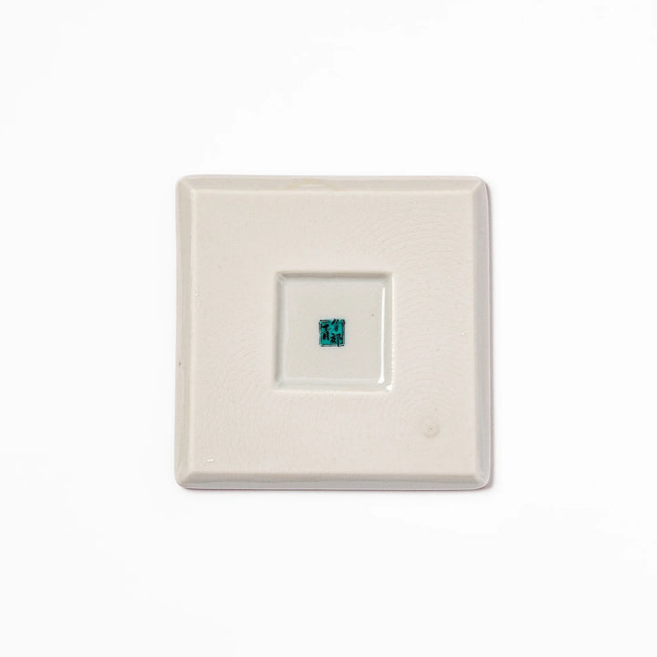 Square Japanese ceramic coaster with a red background decorated with colorful plum and chrysanthemum blossoms, adding elegance and tradition to table settings.