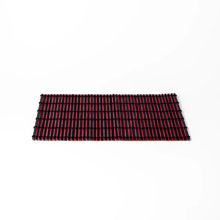 Red and black bamboo table mat with tightly spaced slats and black cord binding, adding bold color and texture to modern Japanese table settings.