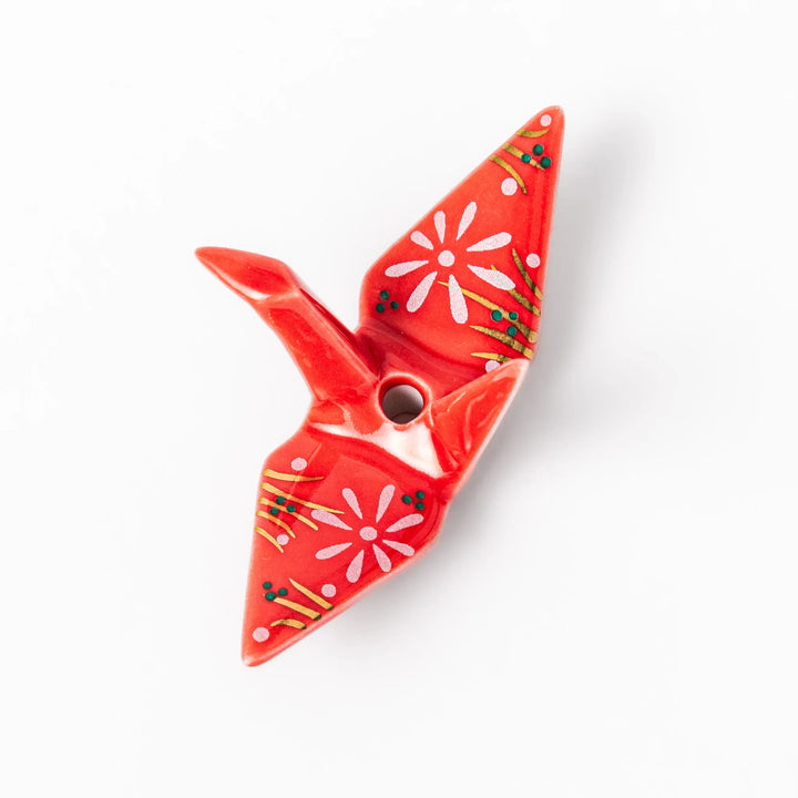 Red ceramic origami crane incense holder with delicate floral details, blending Japanese tradition and modern tableware design