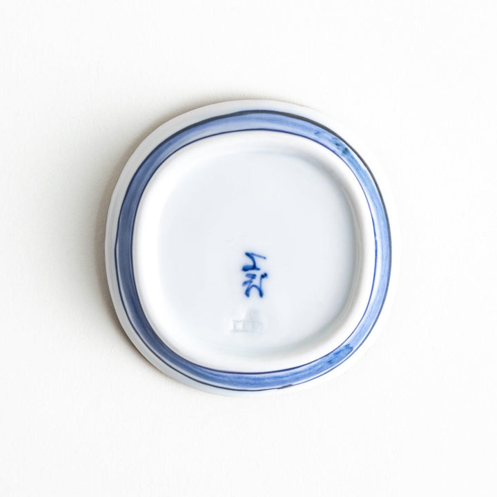 A round plate featuring a large, bold blue flower with a textured brown rim.