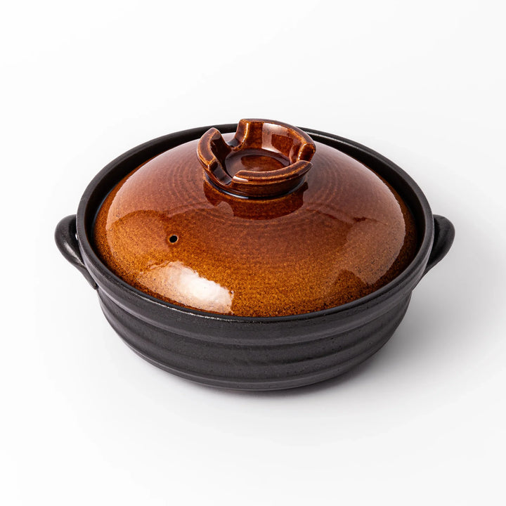 Japanese donabe clay pot with rustic brown glazed lid and black base, induction compatible and perfect for family hot pot meals.