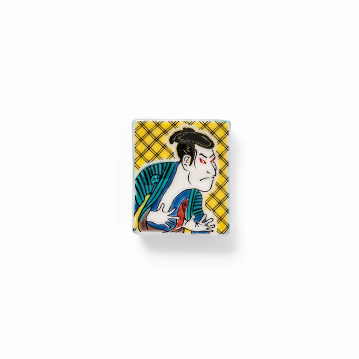 Rectangular Japanese ceramic chopstick rest featuring a bold kabuki actor design inspired by Sharaku’s ukiyo-e, adding dramatic artistry to dining tables.