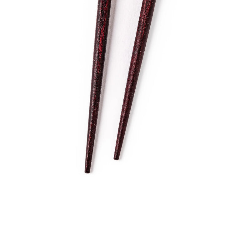 Japanese lacquer chopsticks with shimmering abalone shell inlay and deep red finish, handcrafted for elegant dining.