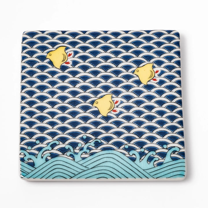 Square Japanese ceramic coaster with traditional blue wave pattern and yellow shorebirds, combining artistry and function for stylish dining table settings.