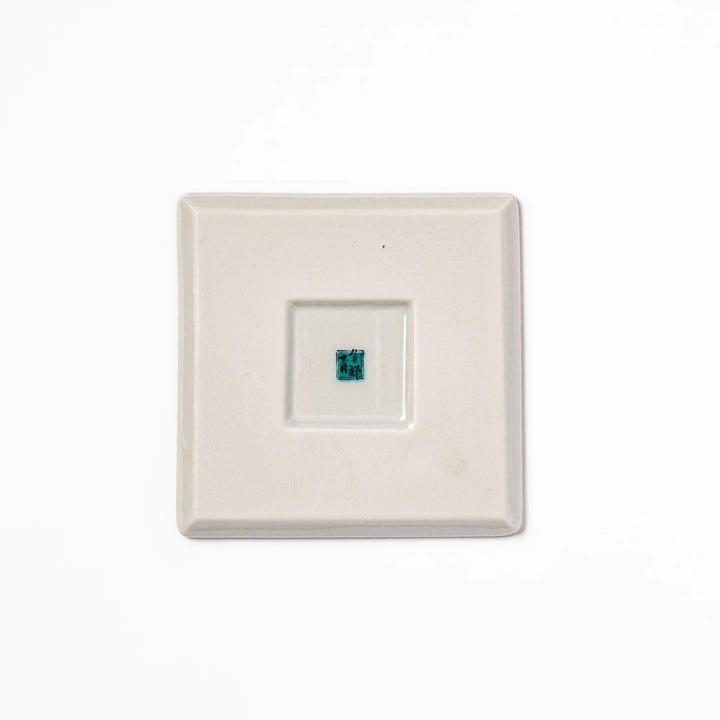 Square Japanese ceramic coaster with traditional blue wave pattern and yellow shorebirds, combining artistry and function for stylish dining table settings.