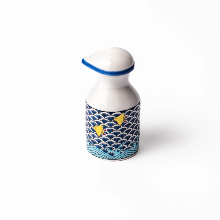 Japanese ceramic soy sauce dispenser featuring a blue wave pattern with yellow shorebirds, combining traditional design and playful detail for table use.