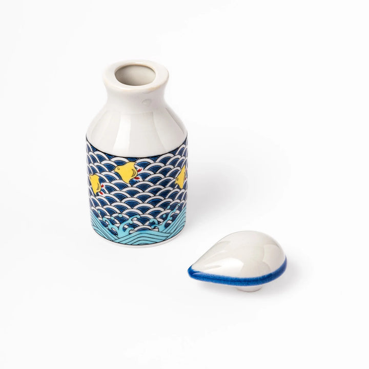 Japanese ceramic soy sauce dispenser featuring a blue wave pattern with yellow shorebirds, combining traditional design and playful detail for table use.