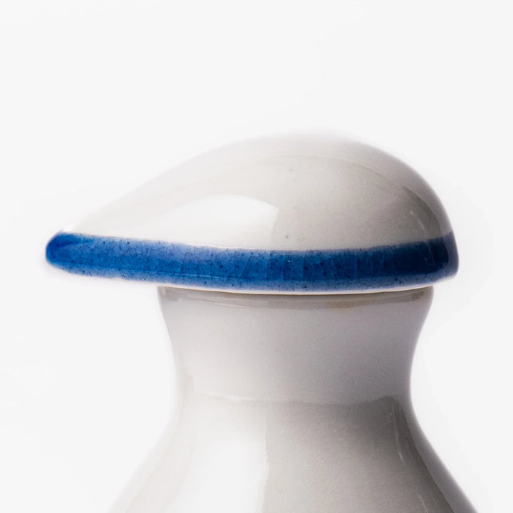 Japanese ceramic soy sauce dispenser featuring a blue wave pattern with yellow shorebirds, combining traditional design and playful detail for table use.