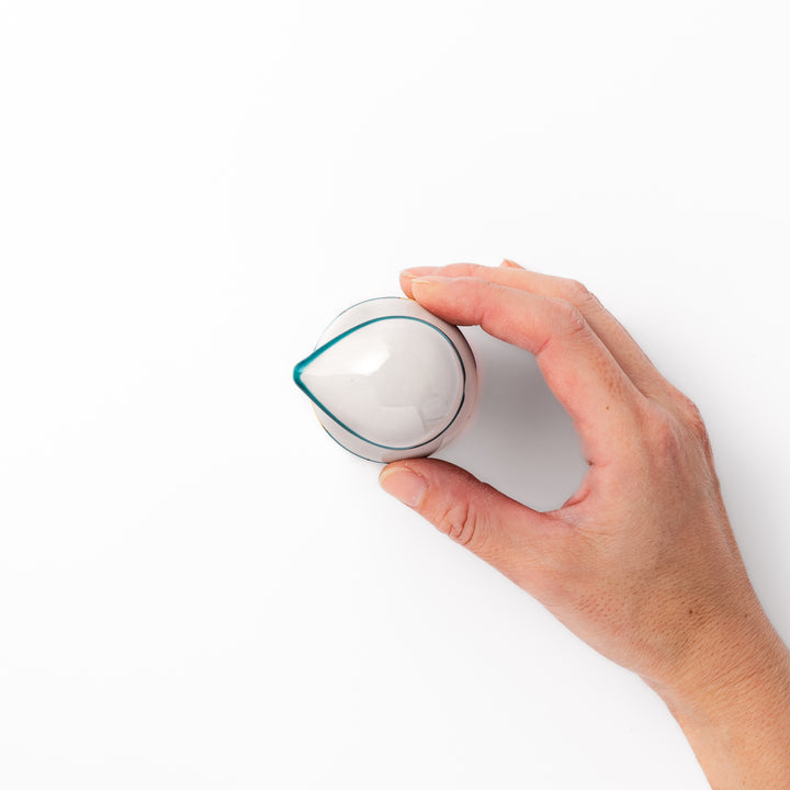 Japanese ceramic soy sauce dispenser with a teal lid and yellow body featuring white plum blossom motifs, handcrafted in Arita Japan.