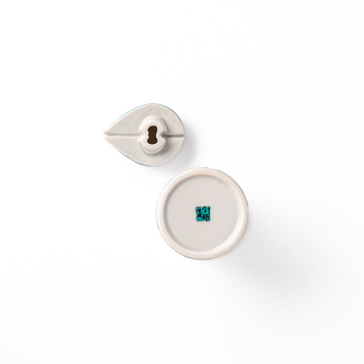 Japanese ceramic soy sauce dispenser with a teal lid and yellow body featuring white plum blossom motifs, handcrafted in Arita Japan.