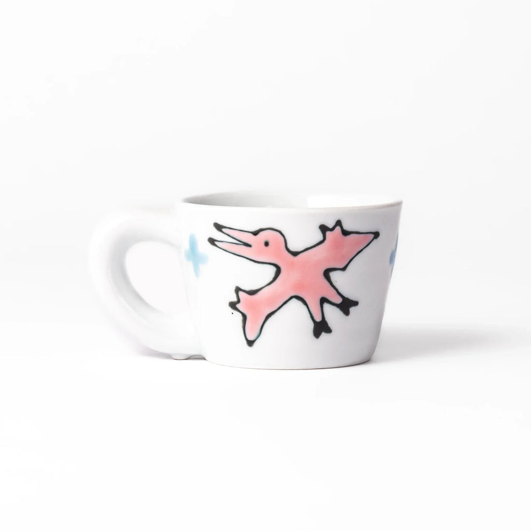 White ceramic kids mug featuring green stegosaurus dinosaur with round handle, shown on white background
