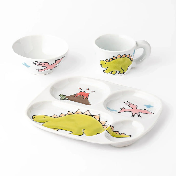 White ceramic kids mug, rice bowl and divided plate set with green stegosaurus, pink pterodactyl and volcano motifs