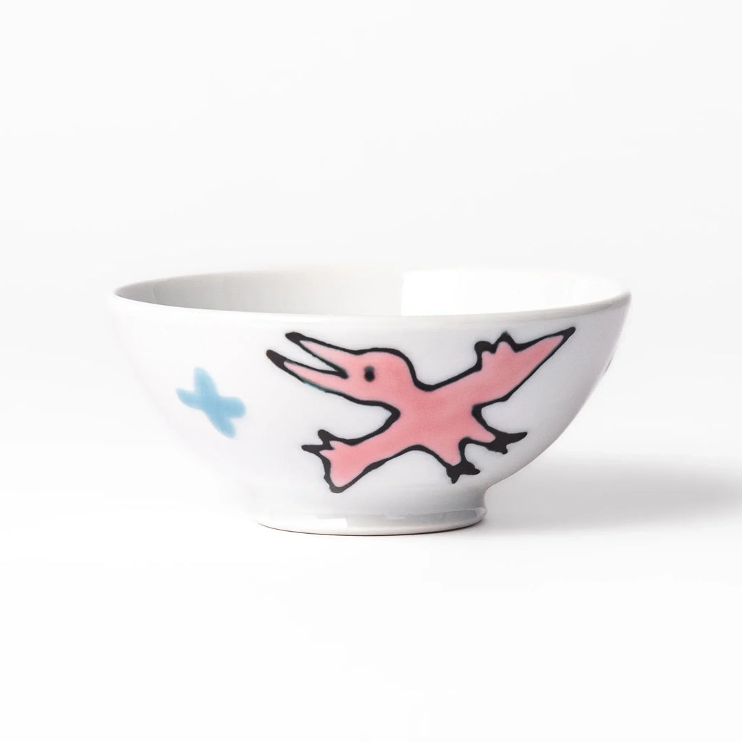 White ceramic kids rice bowl with green stegosaurus dinosaur motif and blue cloud accents