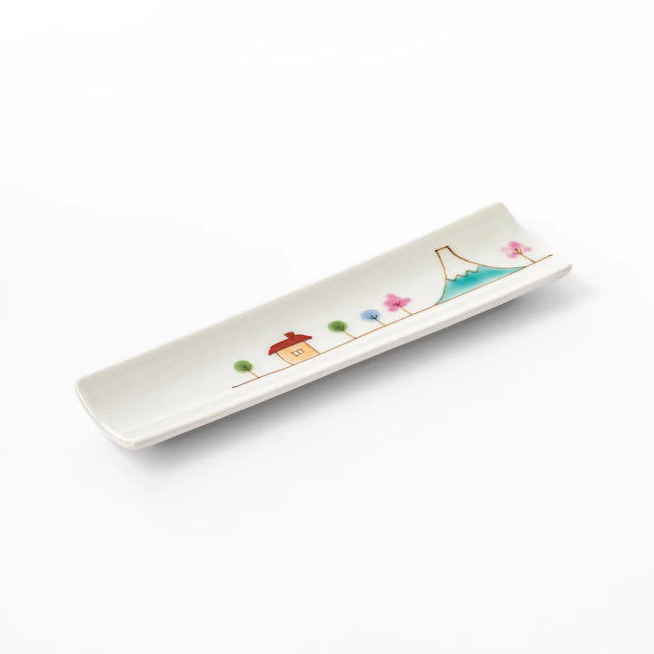 Japanese porcelain chopstick rest with whimsical Japan design featuring Mount Fuji, cherry blossoms, house, and colorful trees