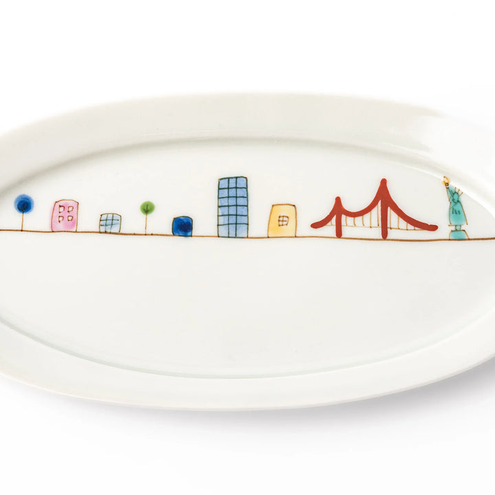 Japanese porcelain oval plate with playful USA cityscape design featuring Statue of Liberty, bridge, and colorful buildings
