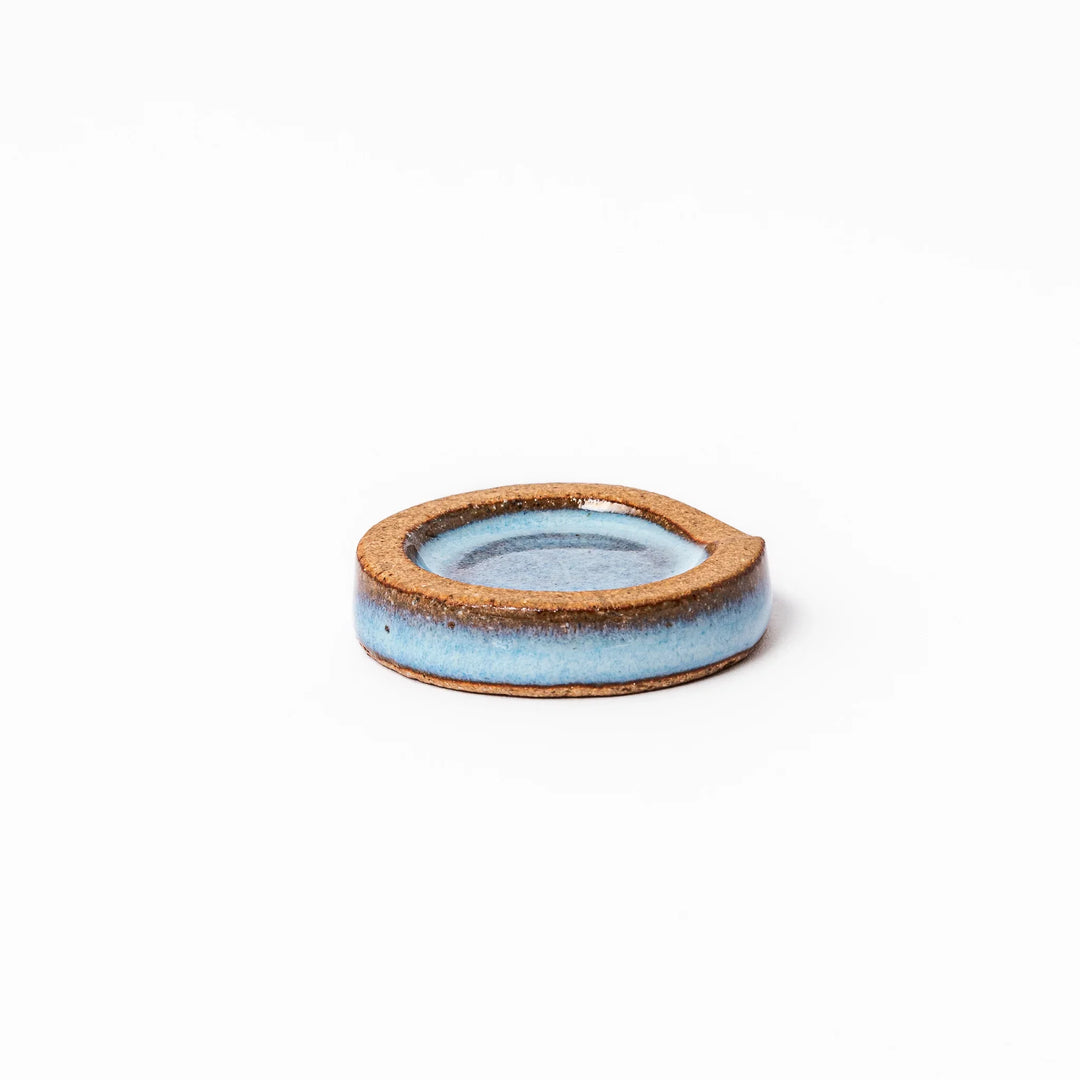 Terracotta blue ceramic chopstick rest with rustic brown rim, handcrafted in Japan to add an elegant accent to everyday dining.