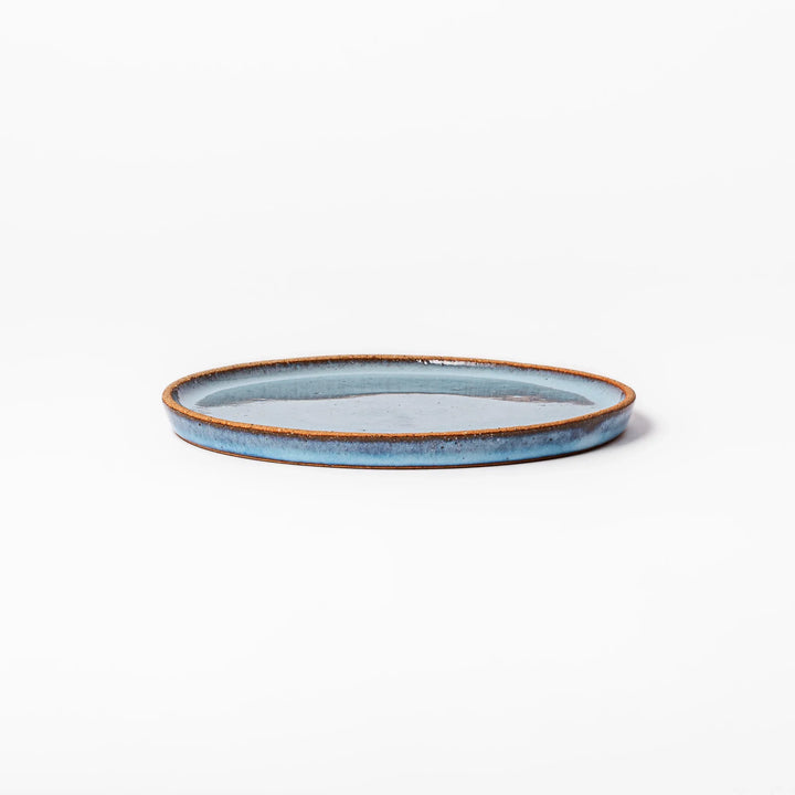 Terracotta blue ceramic dessert plate with rustic brown rim, handcrafted in Japan for serving cake, pastry, appetizers, or everyday meals.