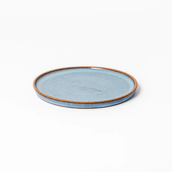 Terracotta blue ceramic dessert plate with rustic brown rim, handcrafted in Japan for serving cake, pastry, appetizers, or everyday meals.
