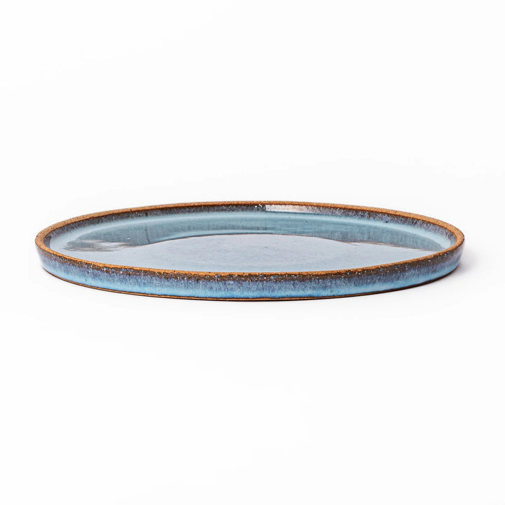 Terracotta blue ceramic dinner plate with rustic brown rim, handcrafted in Japan for serving main dishes, pasta, or everyday meals.