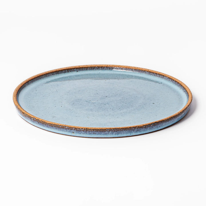 Terracotta blue ceramic dinner plate with rustic brown rim, handcrafted in Japan for serving main dishes, pasta, or everyday meals.