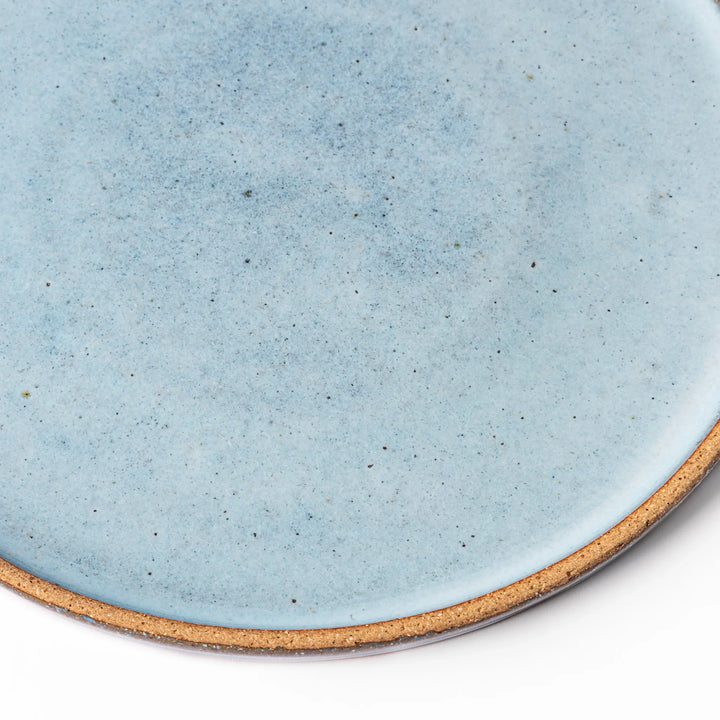 Terracotta blue ceramic dinner plate with rustic brown rim, handcrafted in Japan for serving main dishes, pasta, or everyday meals.