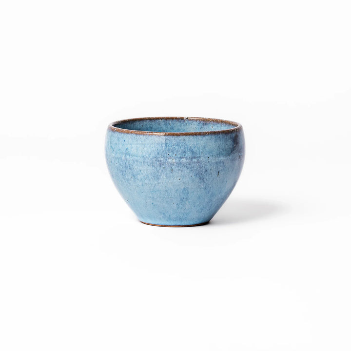 Terracotta blue ceramic tea cup with rustic brown rim, handcrafted in Japan for serving green tea, coffee, or everyday hot drinks.