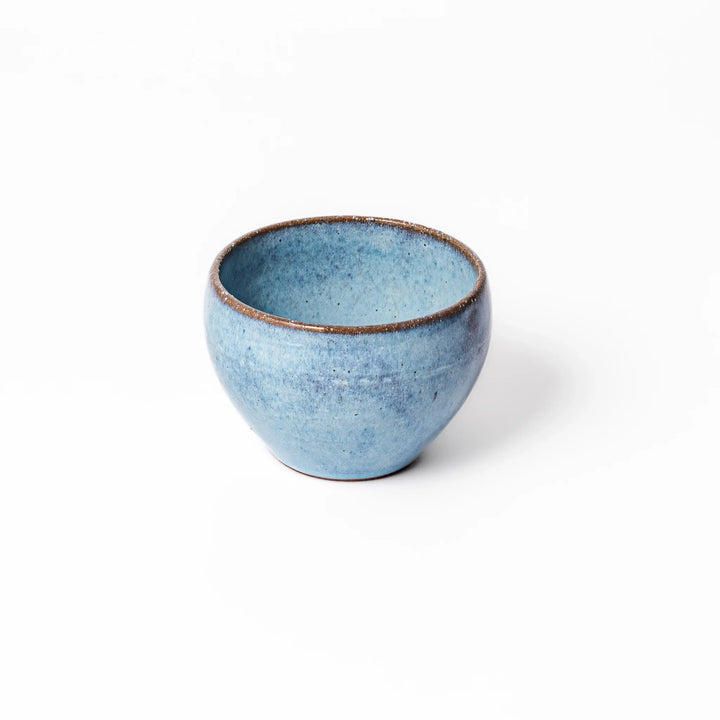 Terracotta blue ceramic tea cup with rustic brown rim, handcrafted in Japan for serving green tea, coffee, or everyday hot drinks.