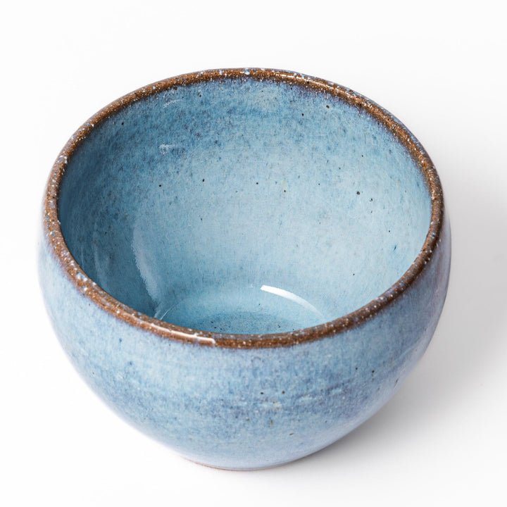 Terracotta blue ceramic tea cup with rustic brown rim, handcrafted in Japan for serving green tea, coffee, or everyday hot drinks.