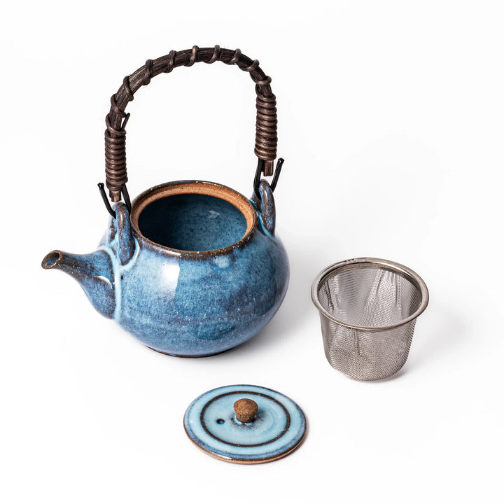 Terracotta blue ceramic teapot with rustic brown rim and woven metal handle, handcrafted in Japan for serving green tea or everyday brewing.