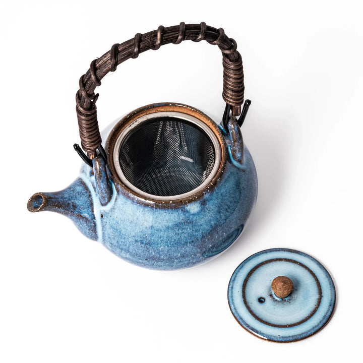 Terracotta blue ceramic teapot with rustic brown rim and woven metal handle, handcrafted in Japan for serving green tea or everyday brewing.
