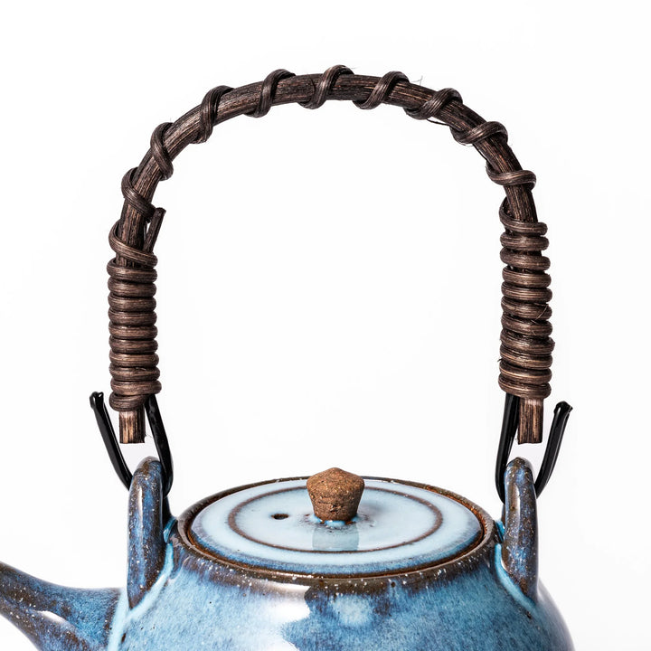 Terracotta blue ceramic teapot with rustic brown rim and woven metal handle, handcrafted in Japan for serving green tea or everyday brewing.