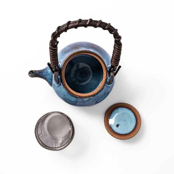 Terracotta blue ceramic teapot with rustic brown rim and woven metal handle, handcrafted in Japan for serving green tea or everyday brewing.