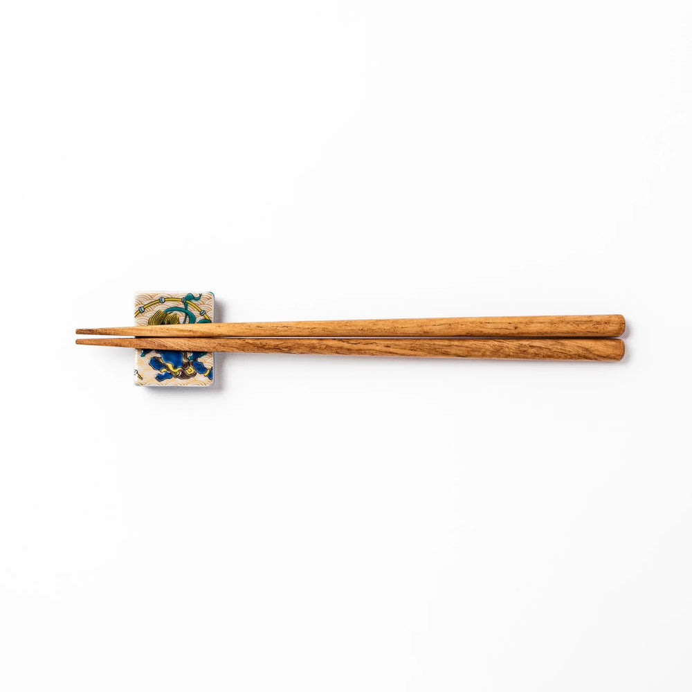 Japanese porcelain chopstick rest featuring the Thunder God design with blue figure and gold wave pattern background.