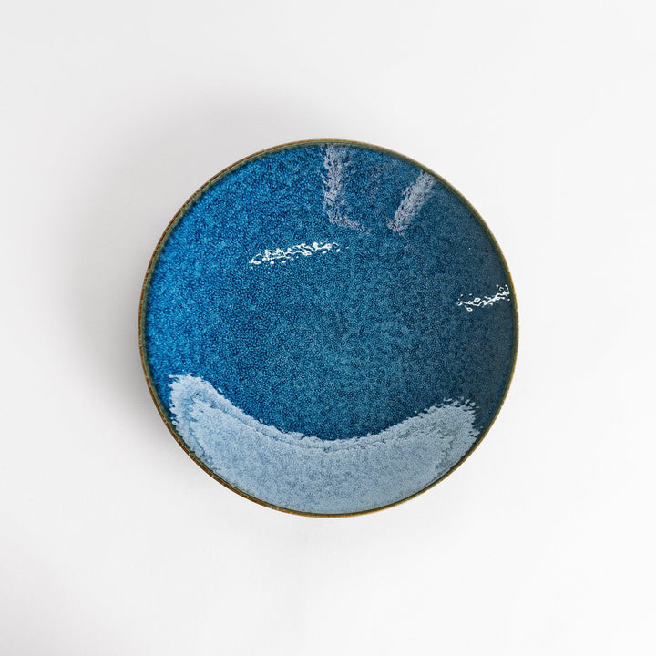 A round dinner plate with a deep blue gradient finish and a subtle textured surface.