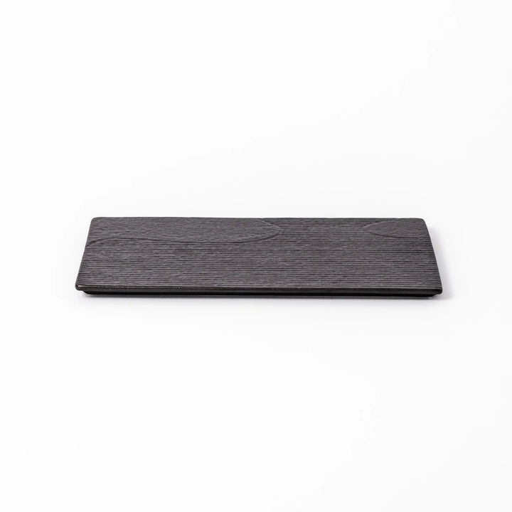 Textured black ceramic dinner plate with ridged woodgrain and matte-gloss accents, ideal for refined Japanese dining and modern presentation.
