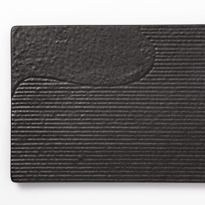 Textured black ceramic dinner plate with ridged woodgrain and matte-gloss accents, ideal for refined Japanese dining and modern presentation.
